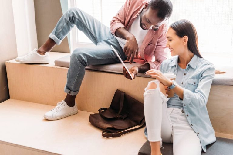 Man and woman sitting, sharing something on a tablet