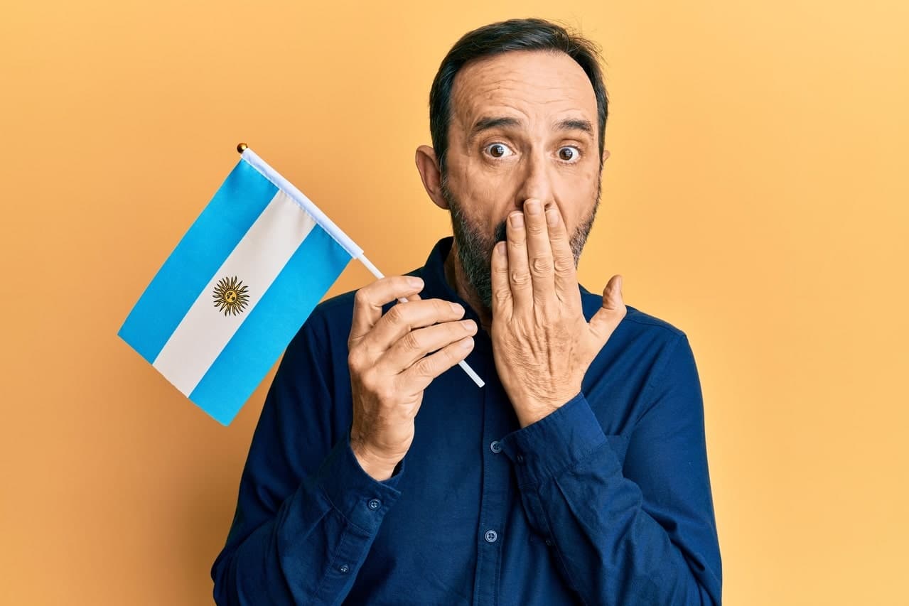 Man holding Argentinian flag with surprised expression