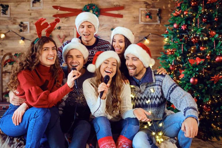 Group of friends singing Christmas carols in festive hats