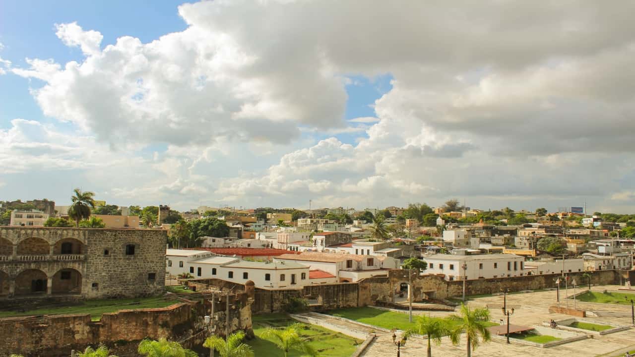 Historical stone buildings and city skyline under a cloudy sky