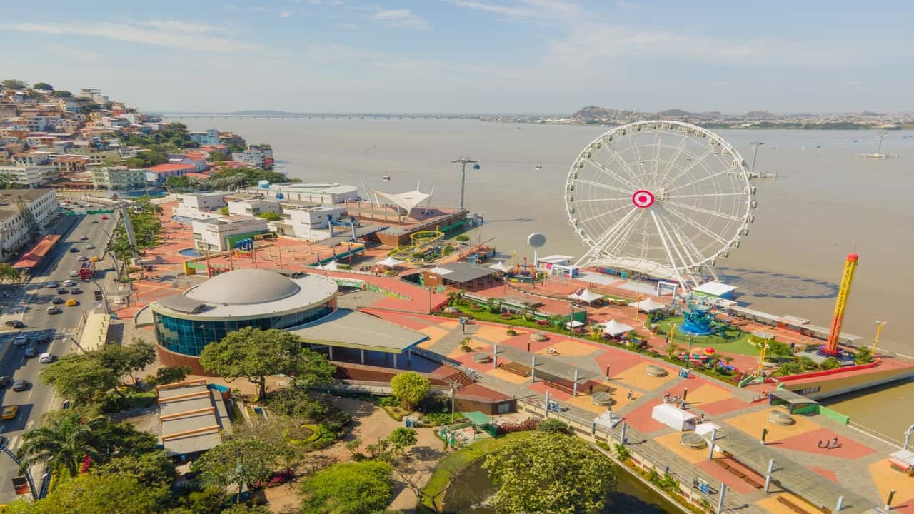 Aerial view of a waterfront amusement area with a Ferris wheel