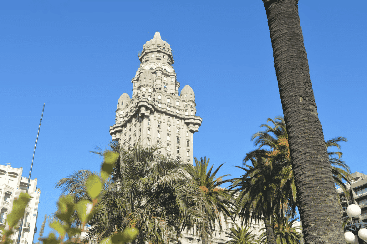 A tall, ornate building with a unique architectural design rises against a clear blue sky