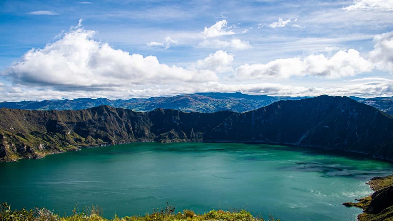 Scenic view of a lake surrounded by mountains and blue skies