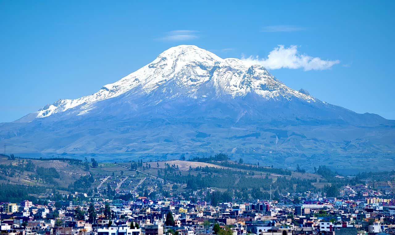 Snow-capped mountain towering over a city landscape