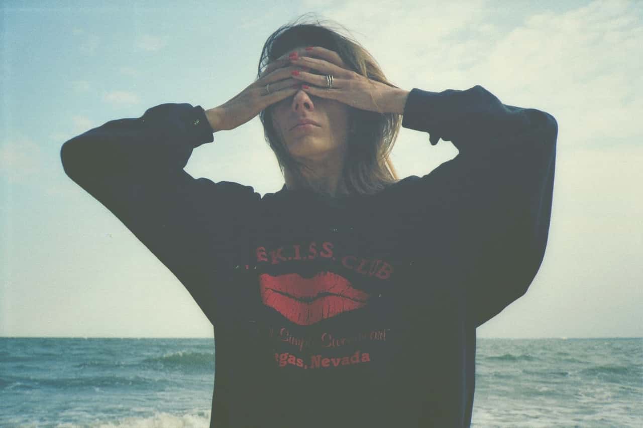 Woman at the beach covering her eyes with hands