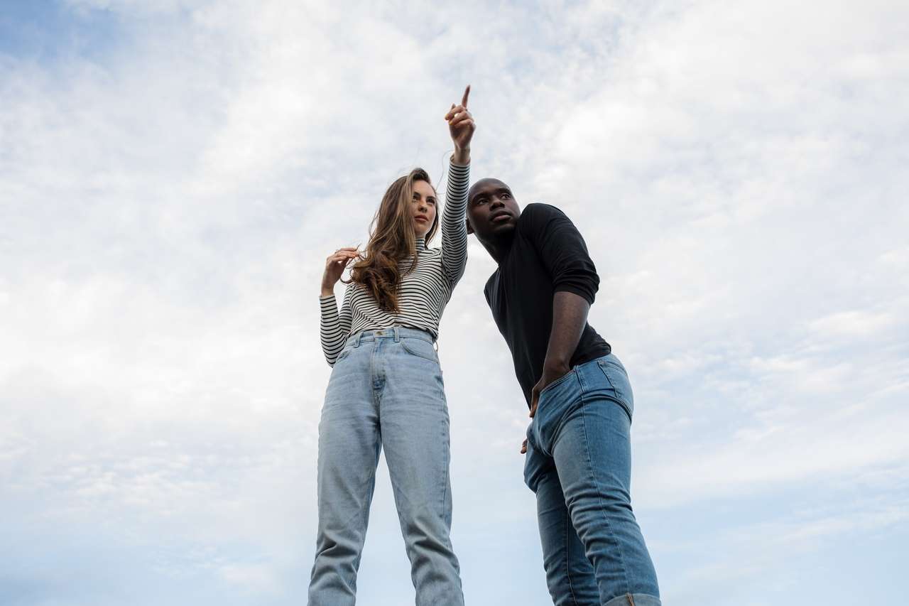 Two people looking ahead, one pointing upward