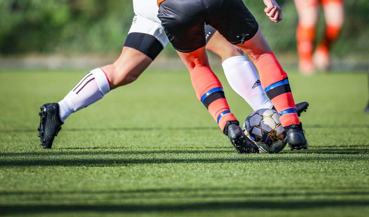 Soccer players battling for possession of the ball on the field