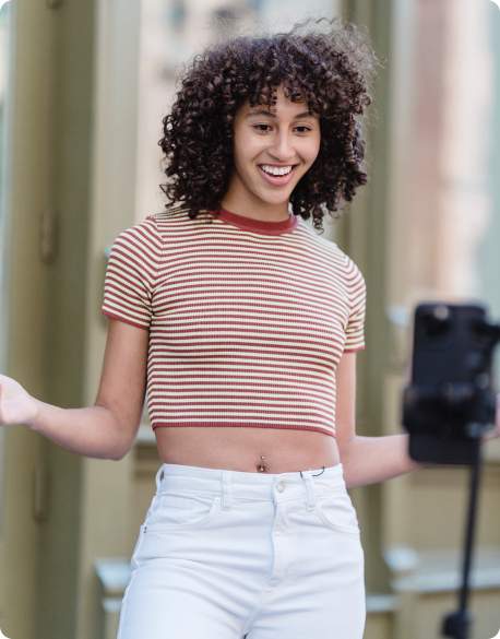 Woman smiling while recording herself on a phone