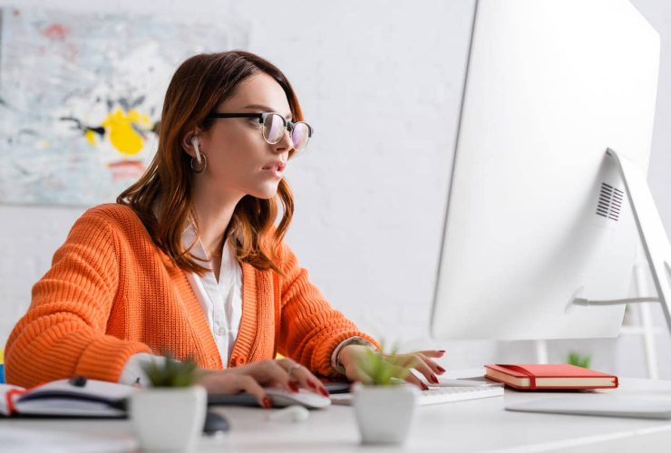 A woman in glasses working on a computer