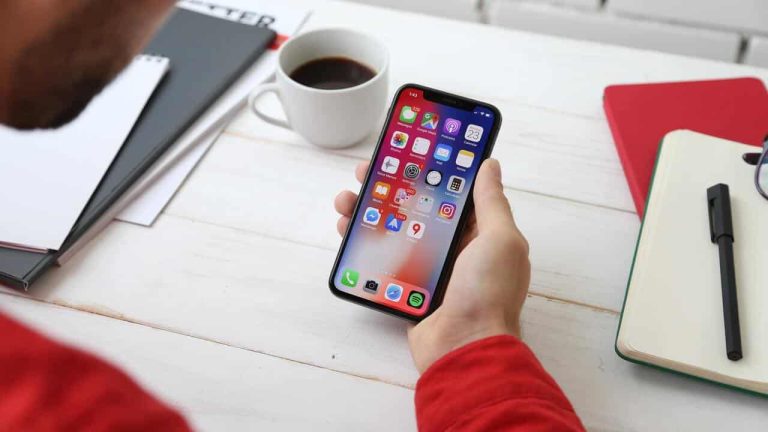 Person holding a smartphone with apps displayed