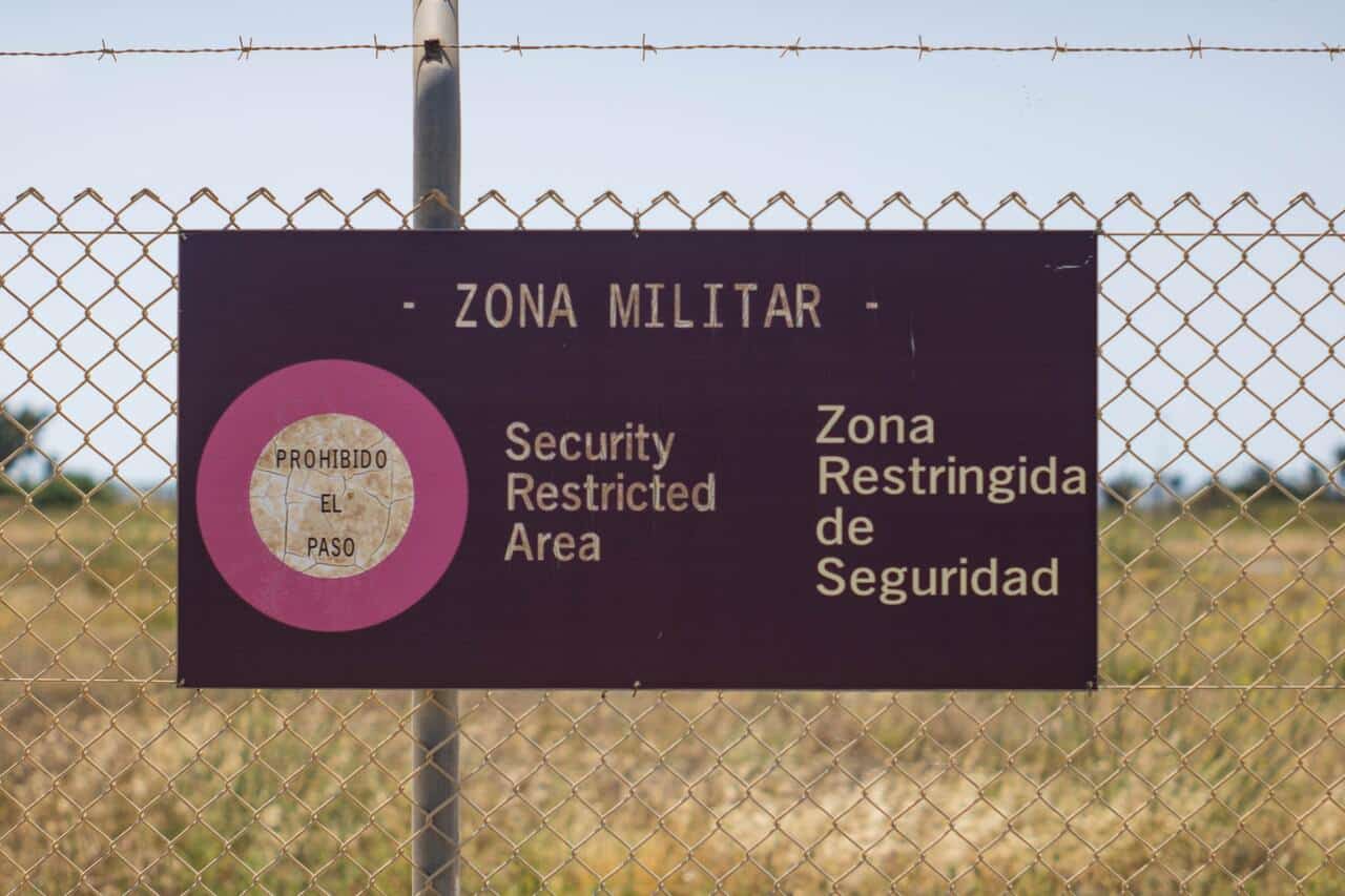 Military zone security warning sign on a wire fence