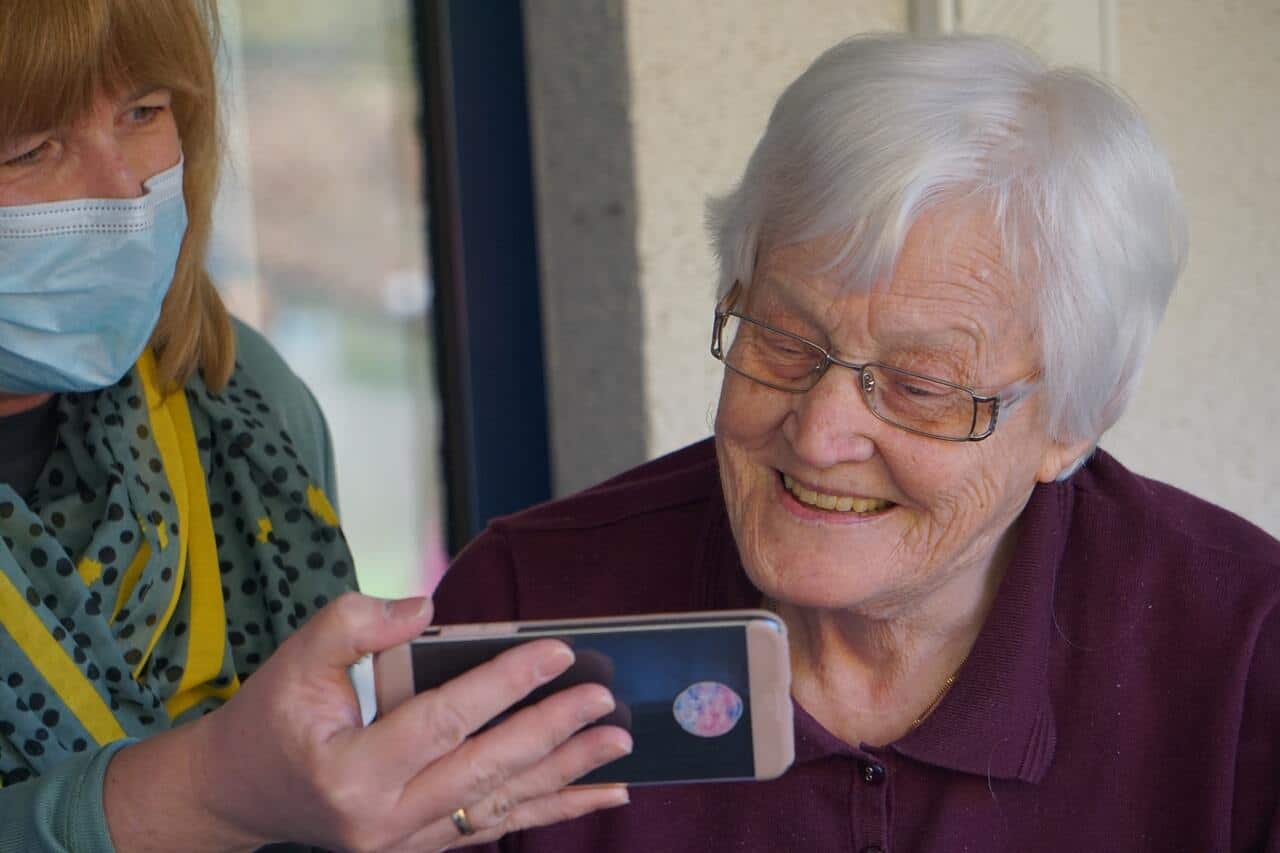 Older woman smiling while looking at a phone screen