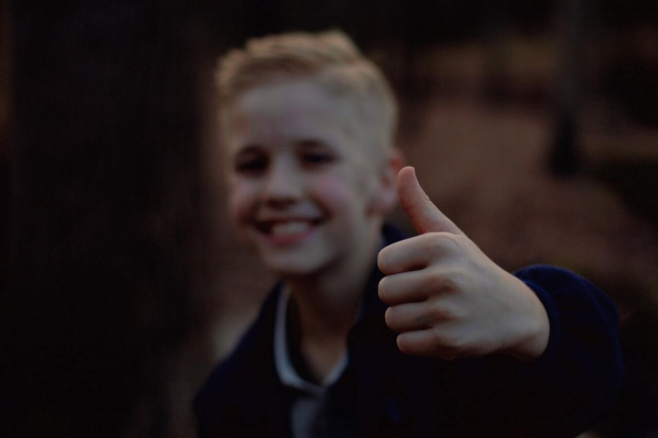 Smiling boy giving a thumbs up gesture