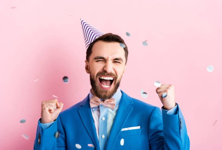 Man celebrating with excitement, wearing a party hat