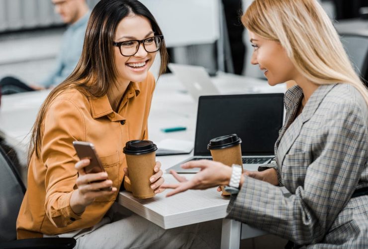 Two women in an office having coffee and talking