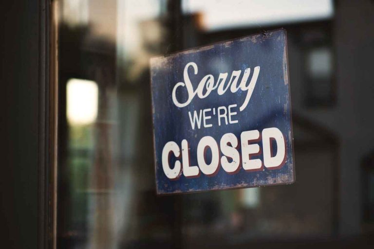 Sorry we're closed sign displayed on a glass door