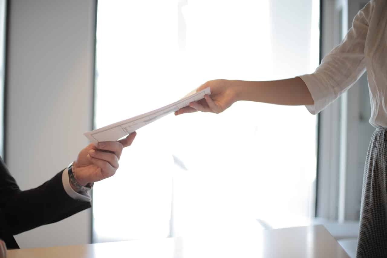 amazon tuition reimbursement (1) Handing over a document between two people