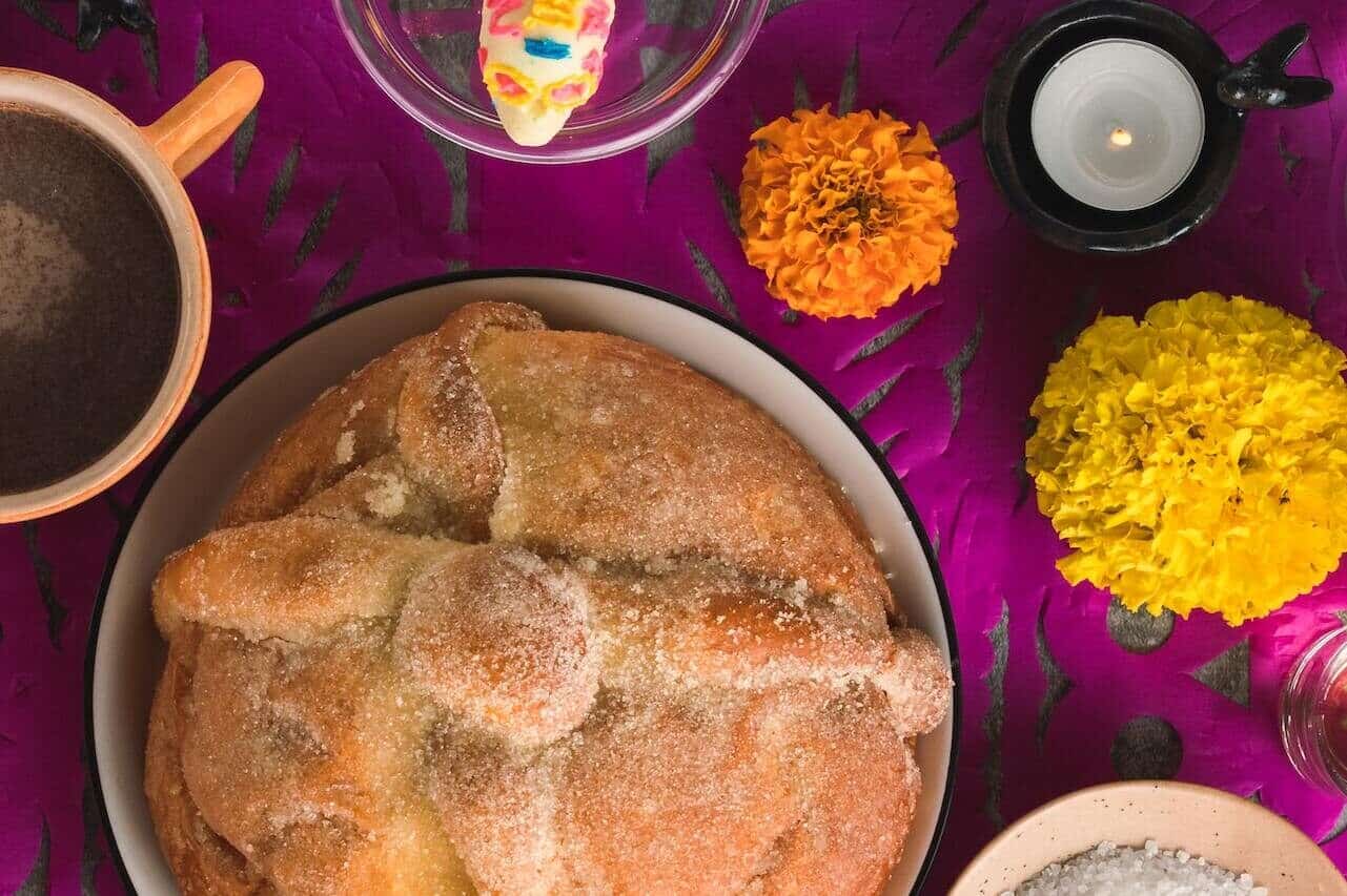 Traditional sweet bread with marigolds, candle, and coffee cup