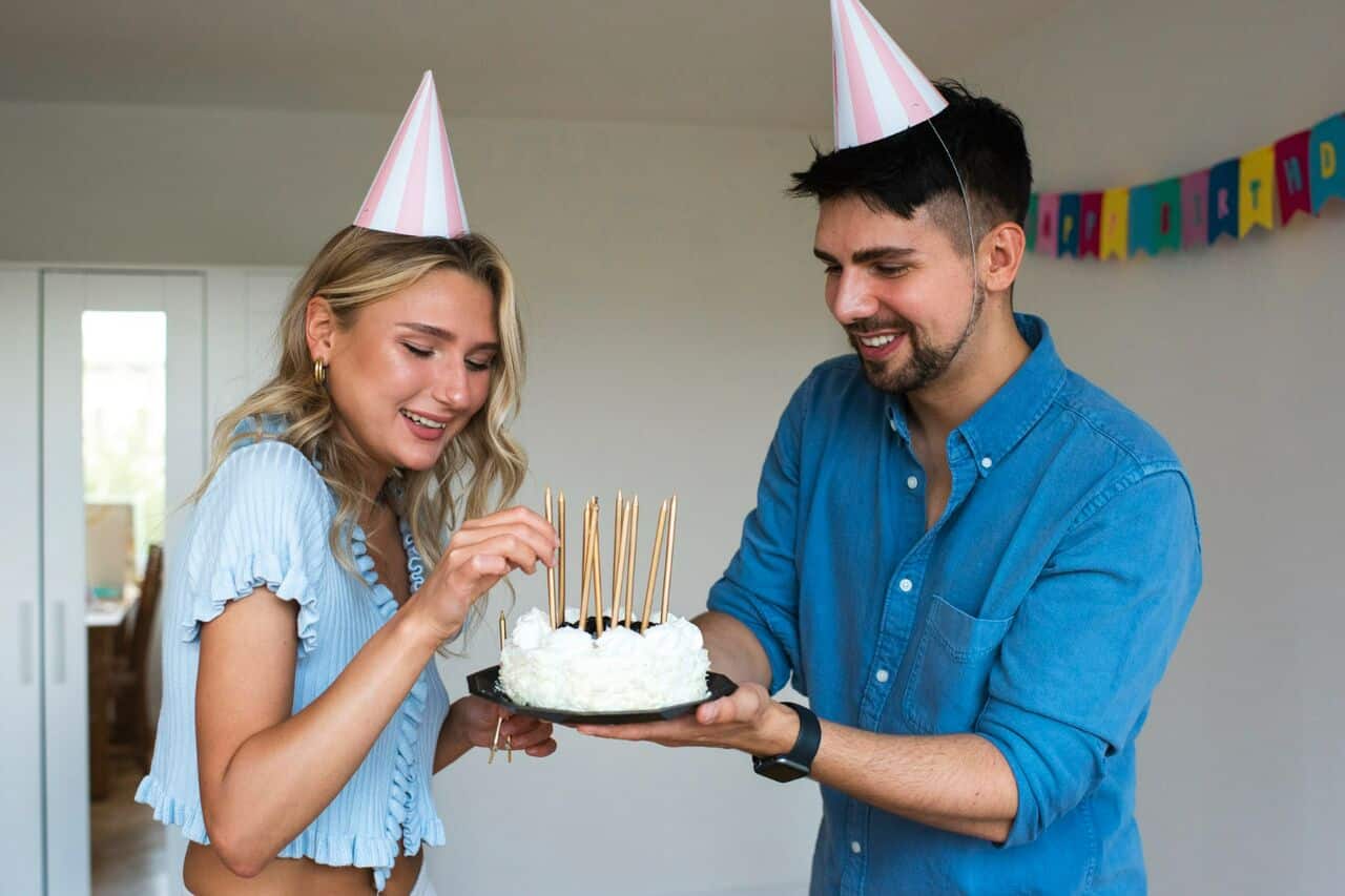 Two people preparing a birthday cake together