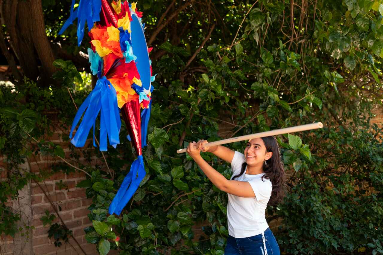 Person hitting a colorful piñata with a stick