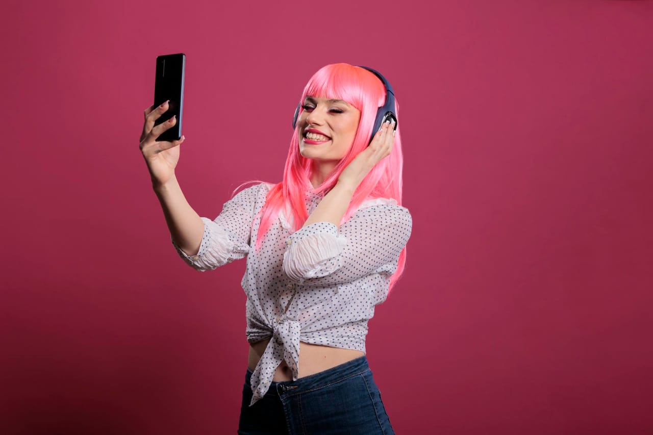 Person with pink hair taking a selfie