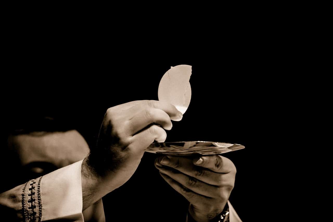 Hands holding communion bread during a religious service