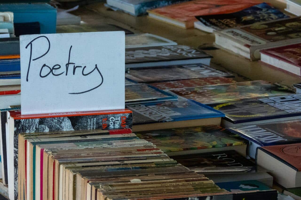 Books on a table with a poetry sign