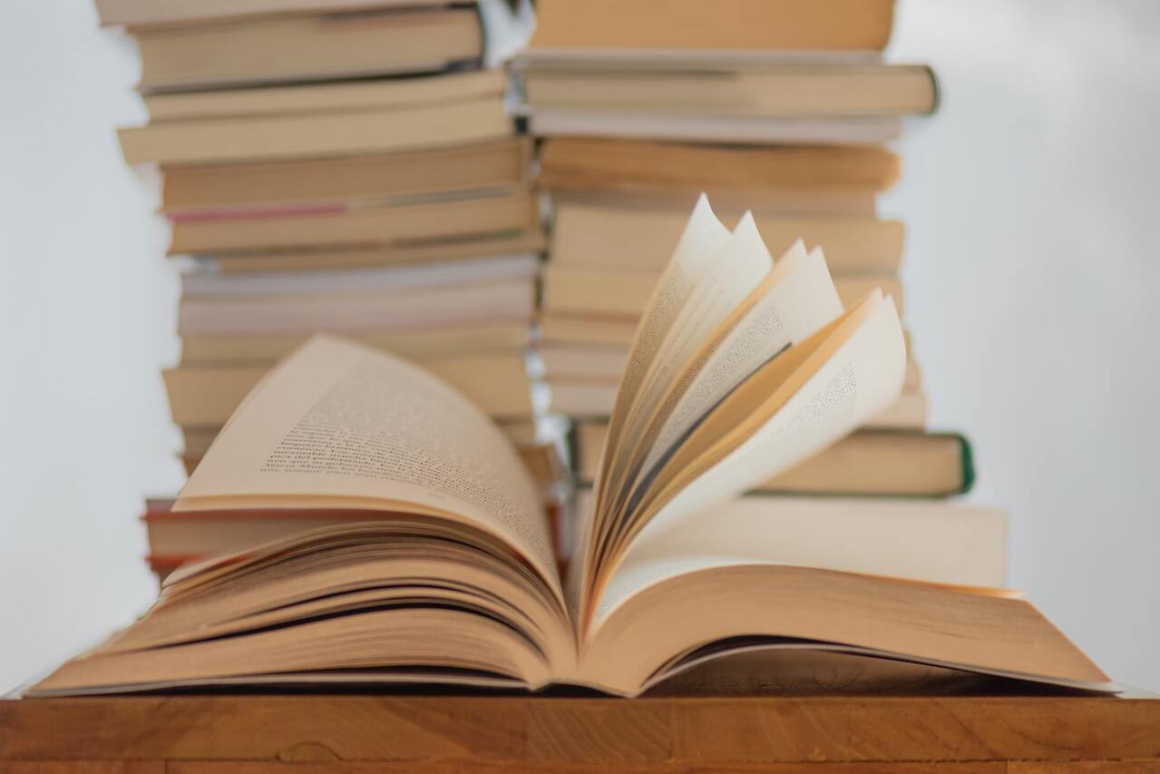 spanish poets (1) Open book on a table with stacked books