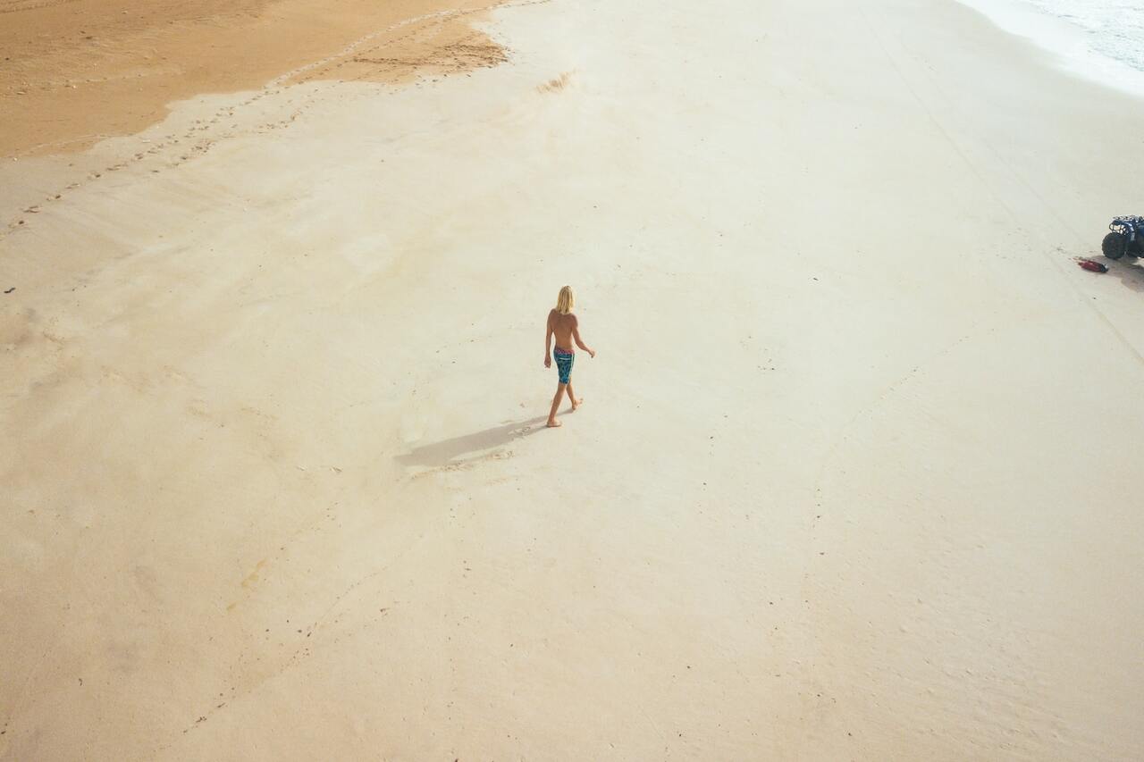 Person walking alone on a sandy beach