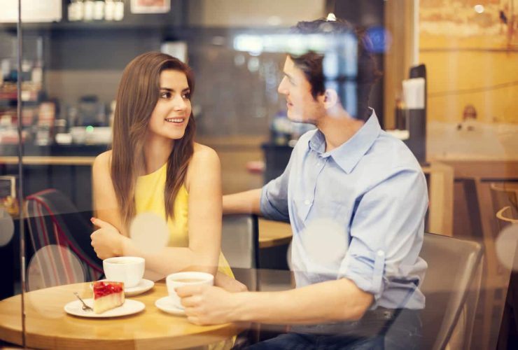 Couple enjoying coffee and dessert while talking at a cafe