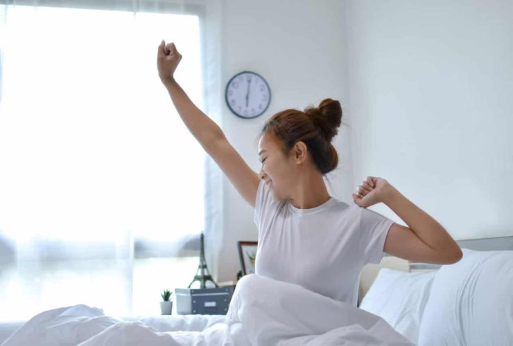 Woman stretching in bed after waking up in the morning