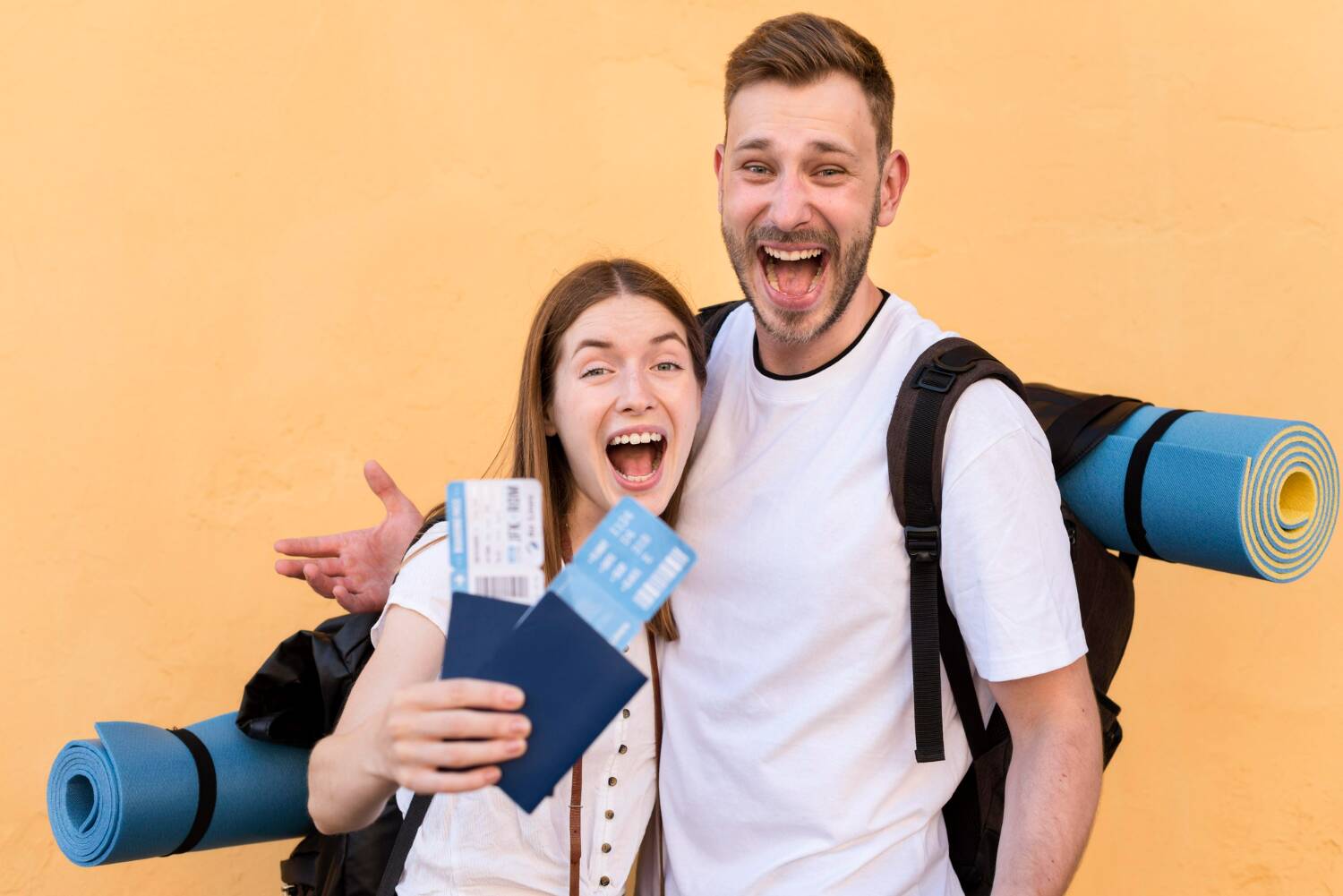 A happy couple holding travel tickets and passports