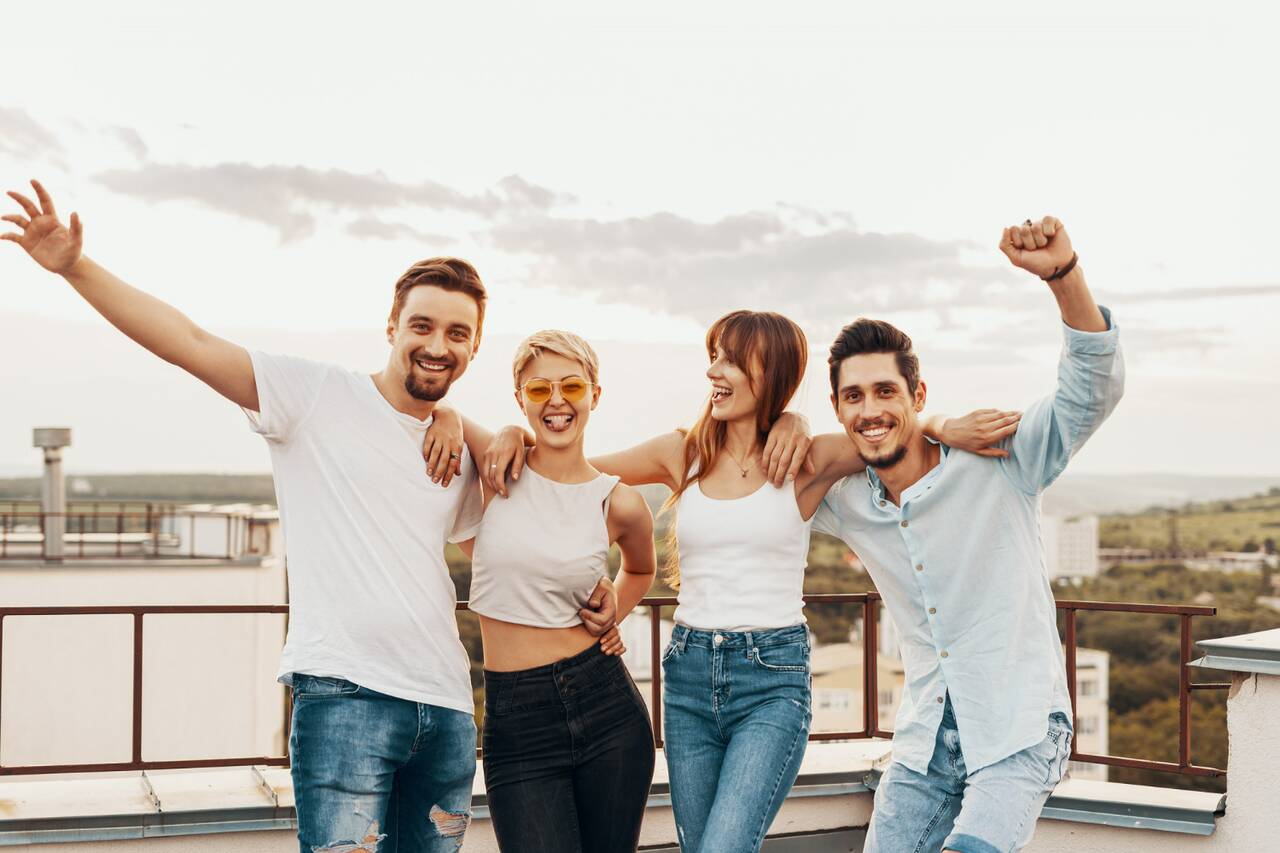 Group of friends smiling and celebrating on a rooftop