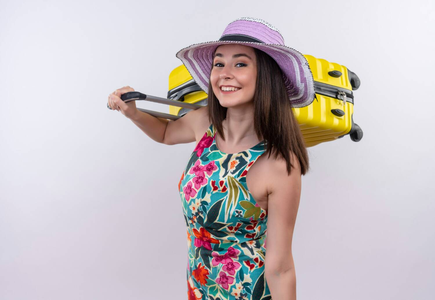 woman in floral dress carrying yellow suitcase