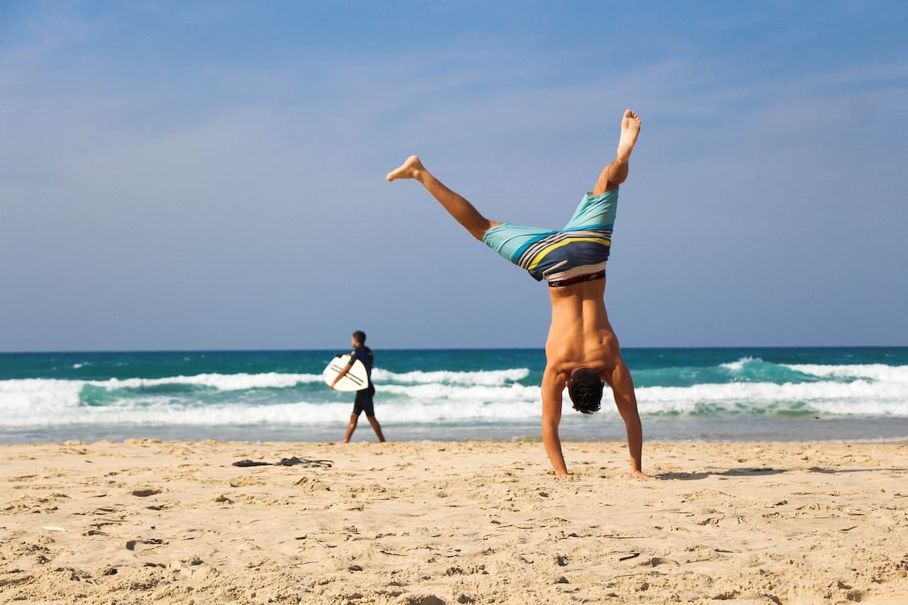 Man doing handstand on the beach