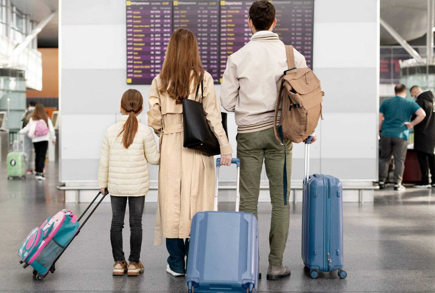 family checking flight information at the airport terminal