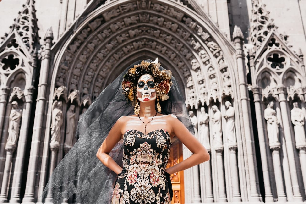 woman in traditional skull makeup standing outside