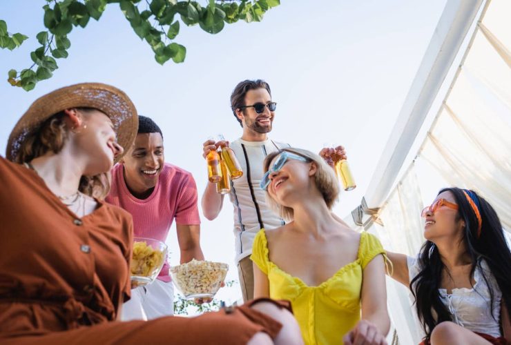 Group of friends enjoying an outdoor gathering with drinks and snacks