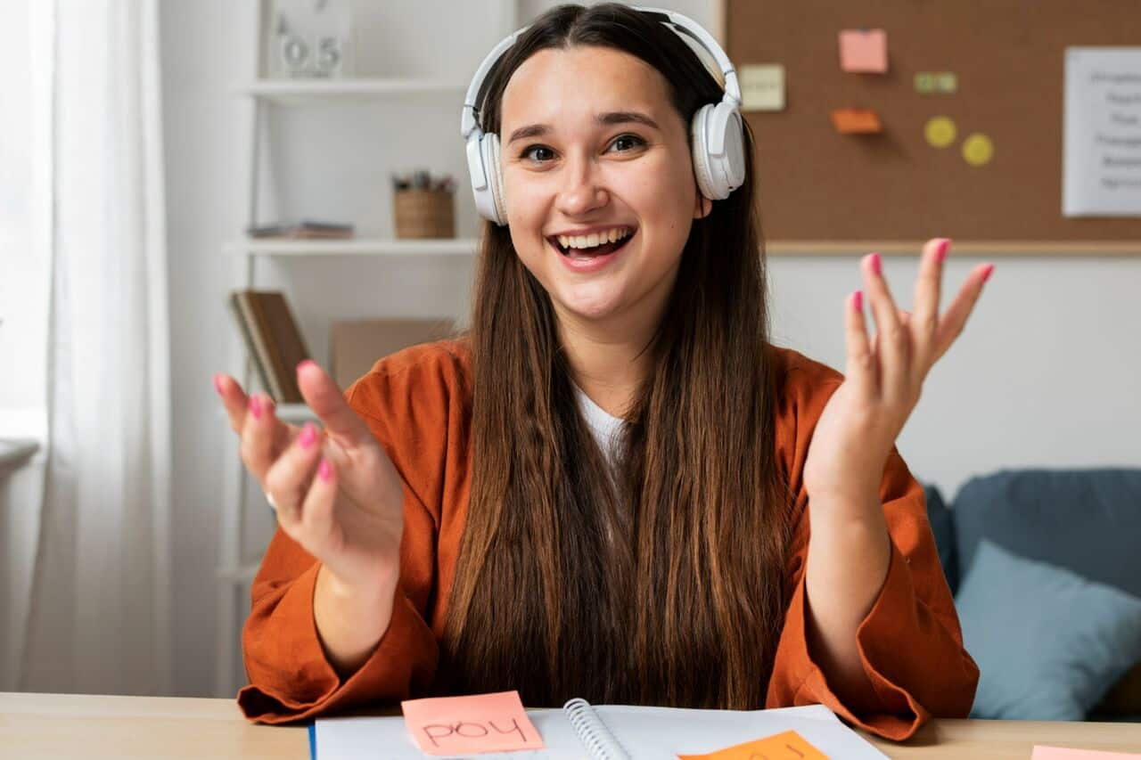 Smiling woman wearing headphones while studying