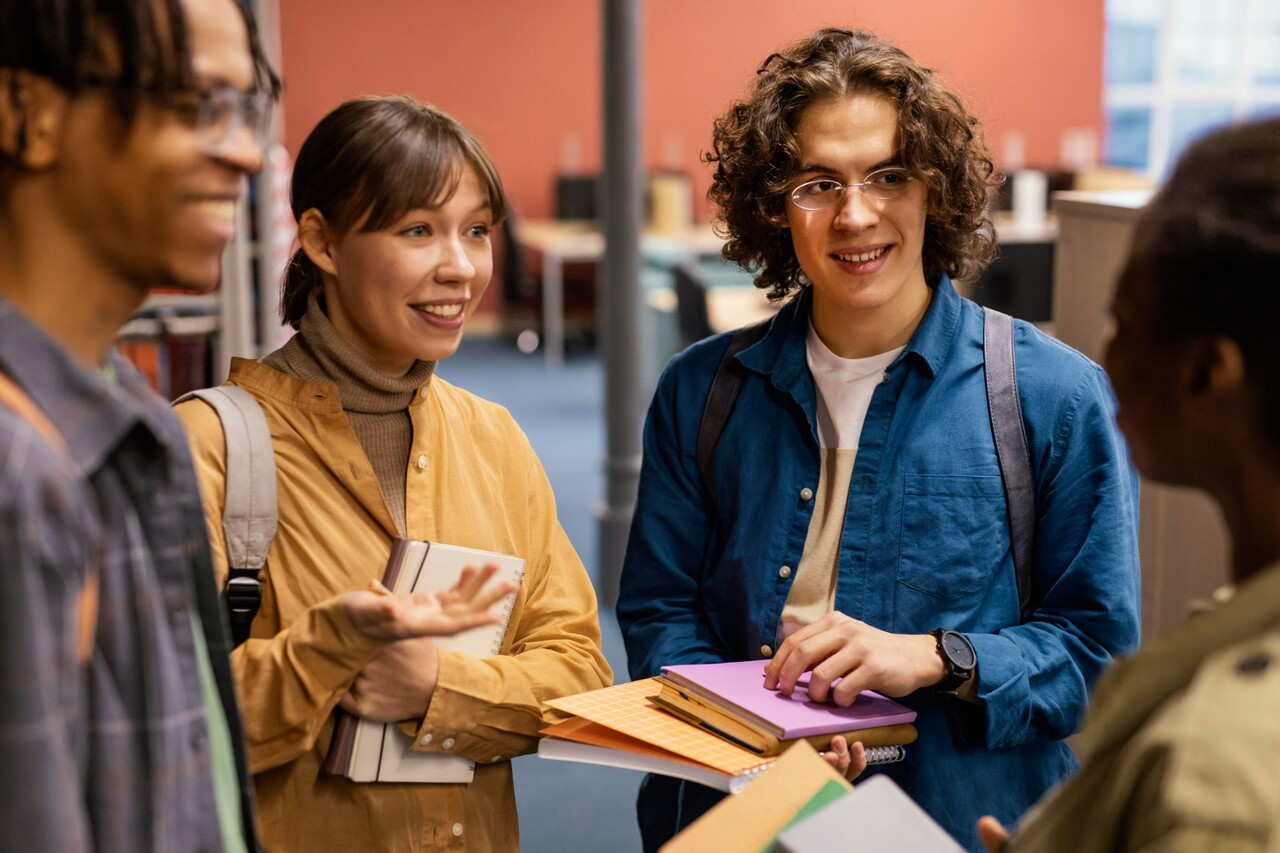 Group of students talking while holding books