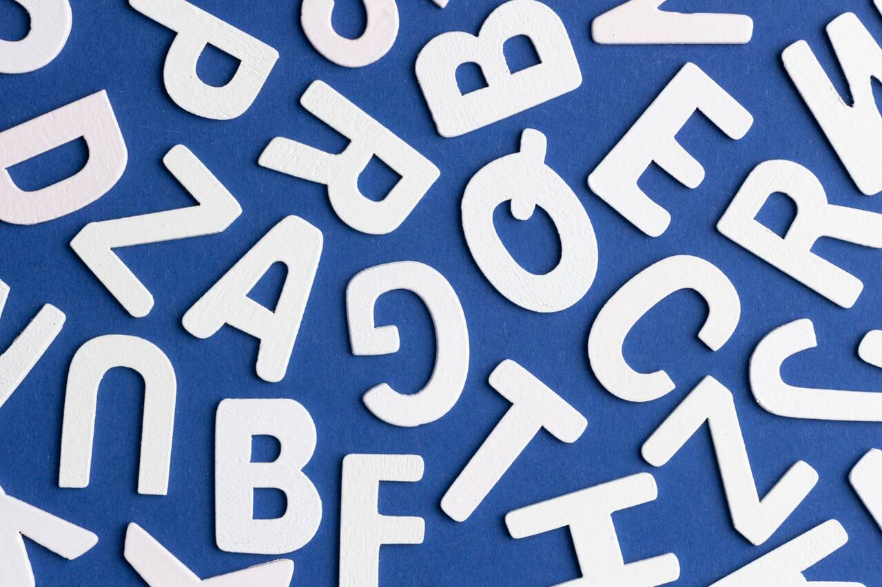 Scattered white alphabet letters on a blue background.