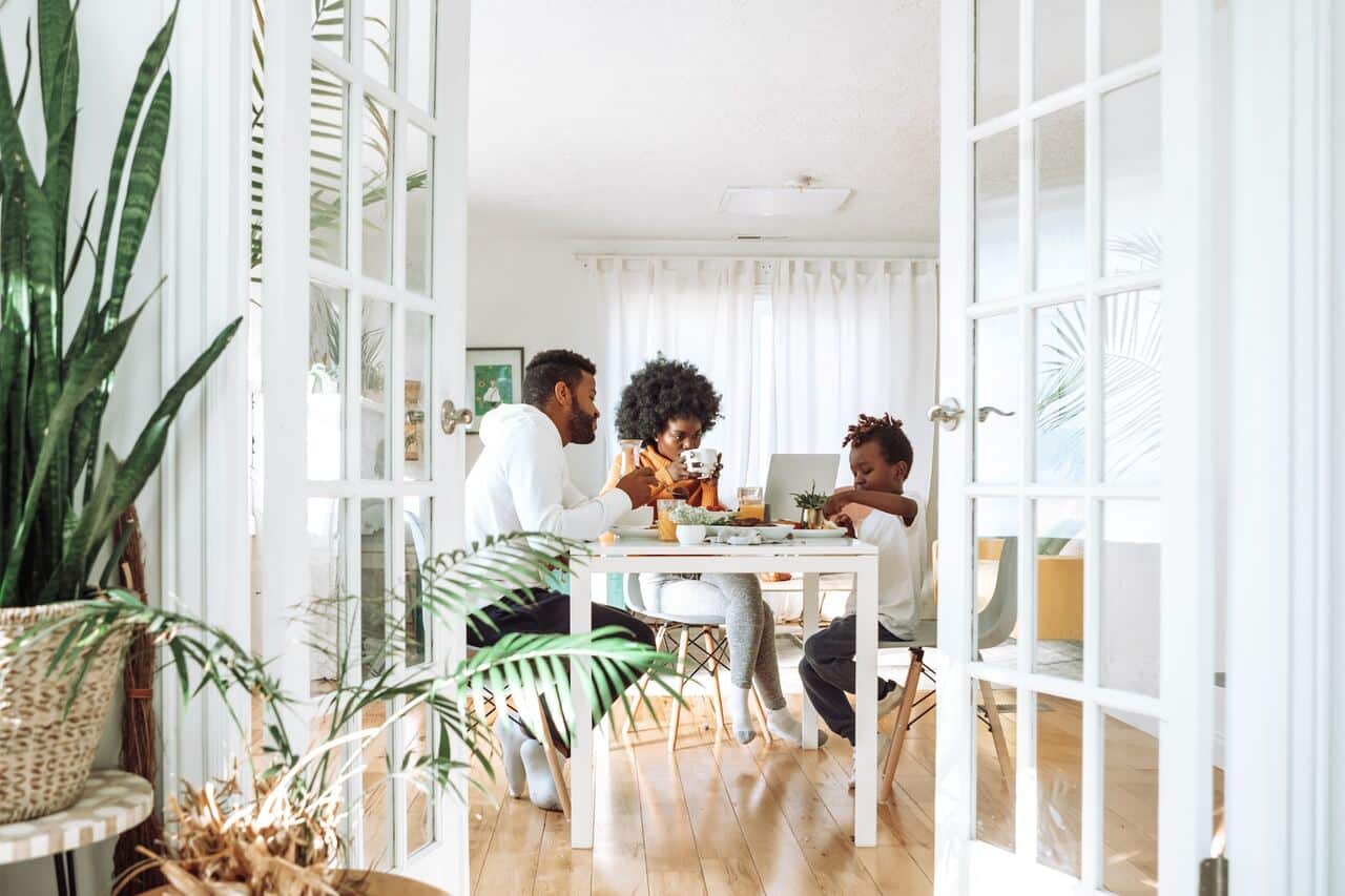 Family having breakfast together at dining table indoors.