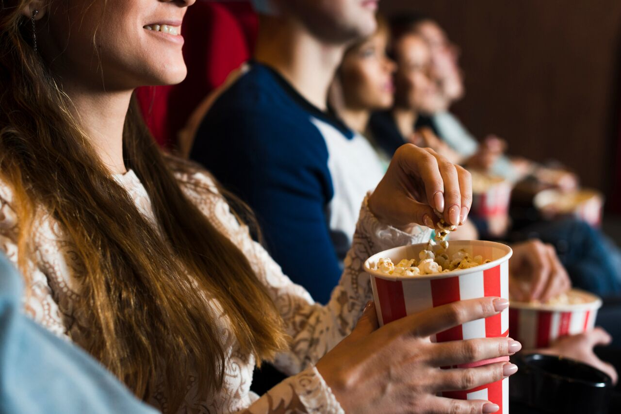 People watching a movie with popcorn