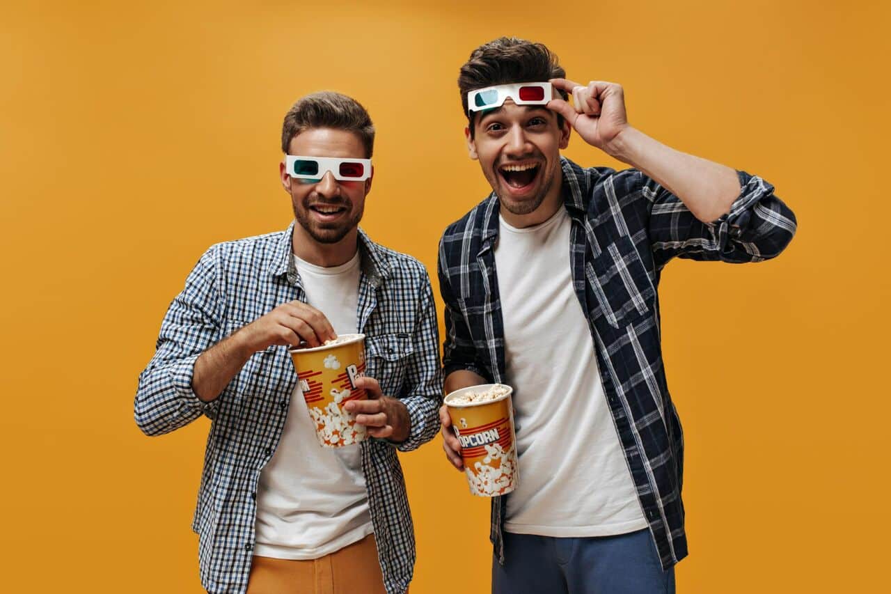 Two men with popcorn wearing 3D glasses