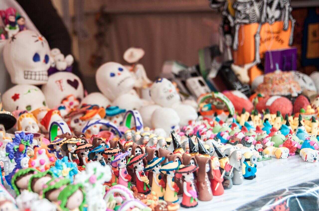 Colorful Day of the Dead figurines and sugar skulls on display at a market