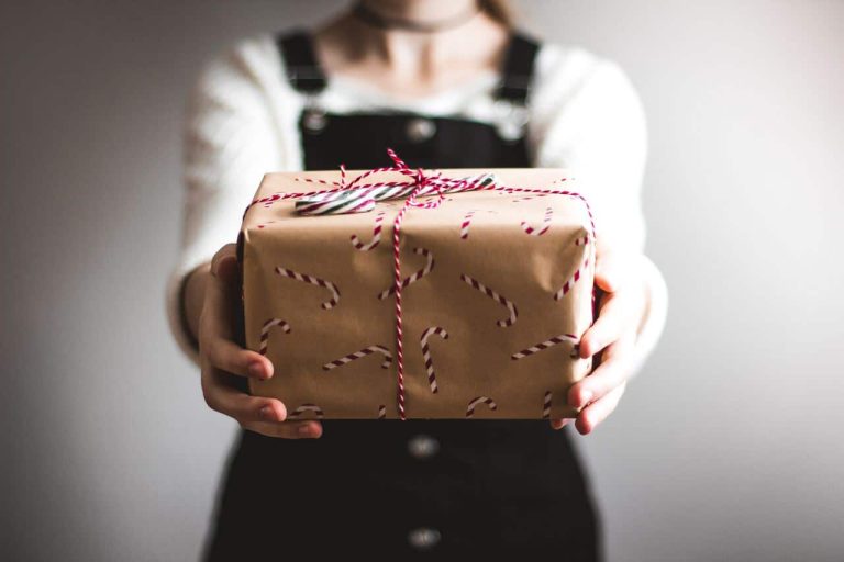 Person holding out a wrapped holiday gift