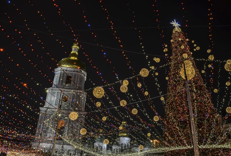 Christmas lights draped over a church and large tree