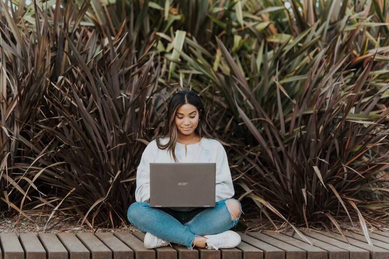 Person sitting outside working on laptop