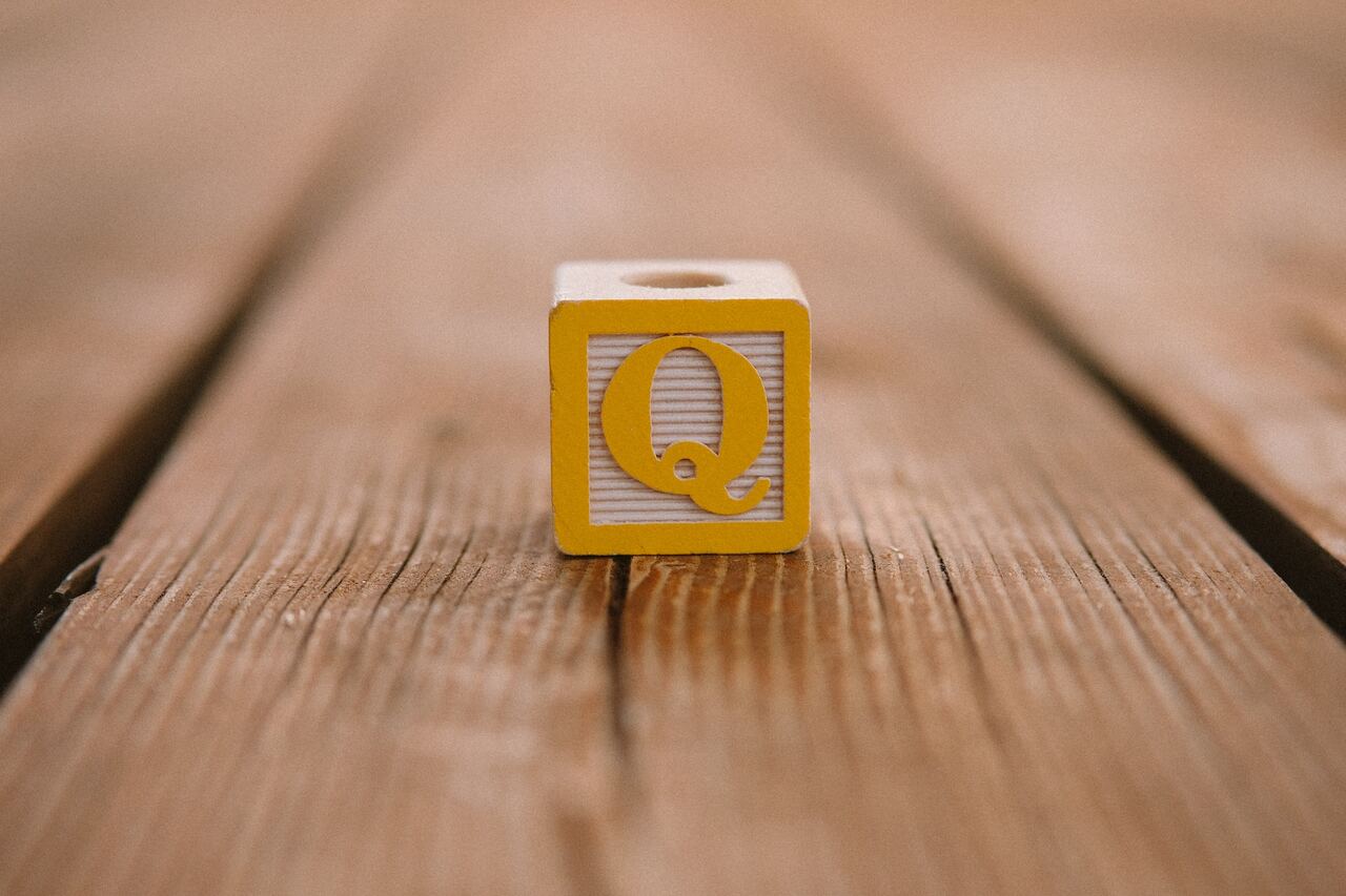 Yellow block with letter Q on wooden surface