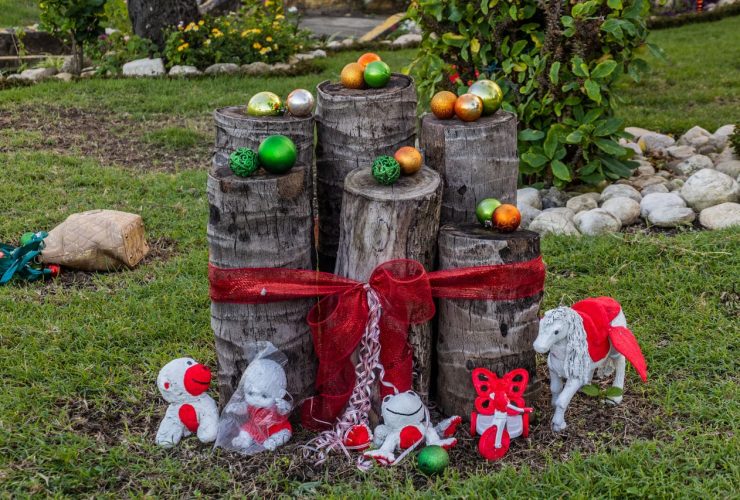 Stacked logs with Christmas decorations and ornaments.